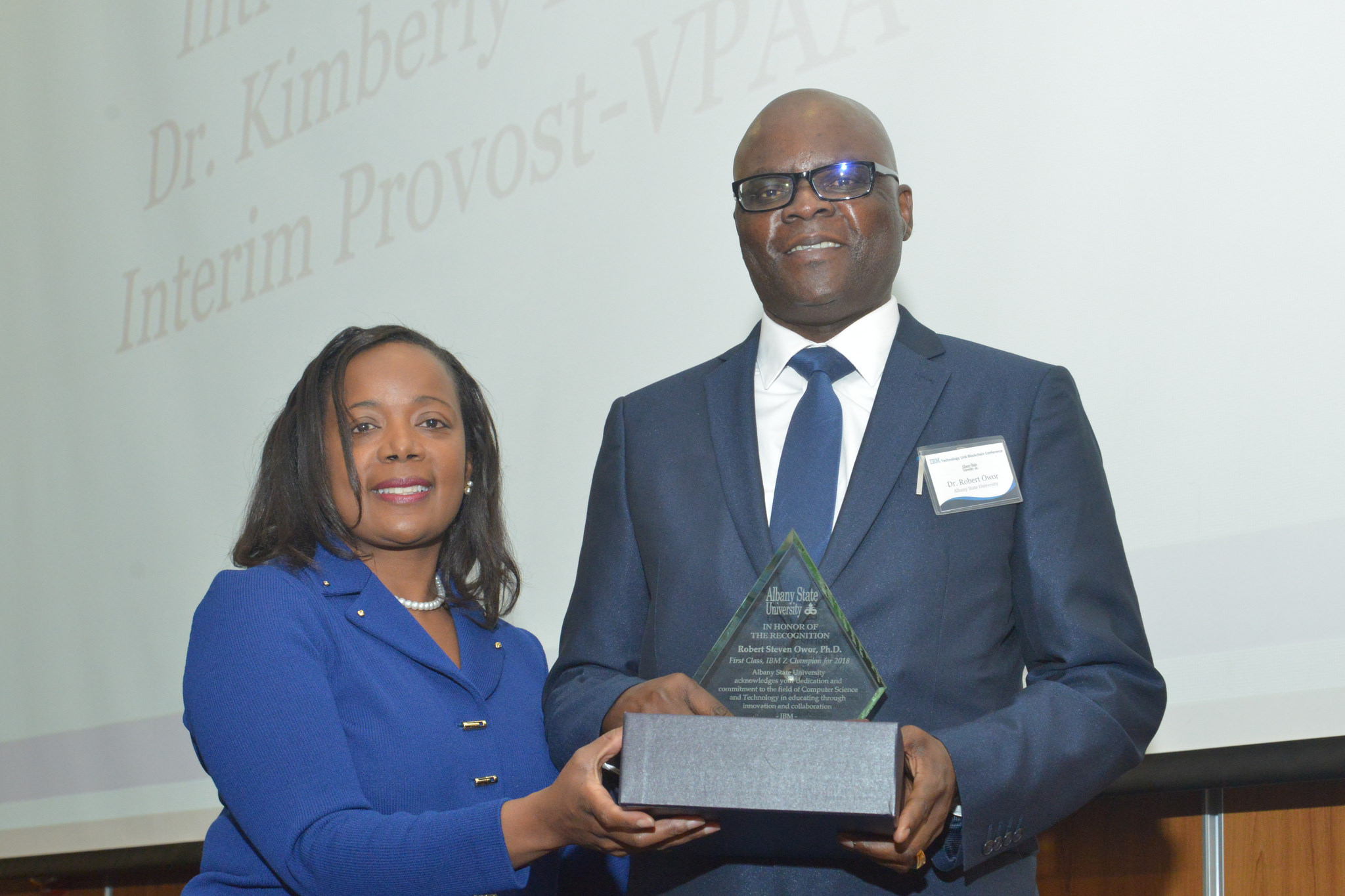 Dr. Robert Owor (right) receives IBM Z Champions award from Dr. Kimberly Holmes, ASU Interim Provost and Vice President for Academic Affairs.